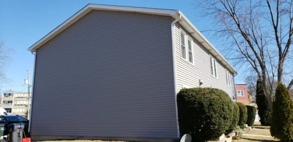 side view of a house with a new gray siding installation